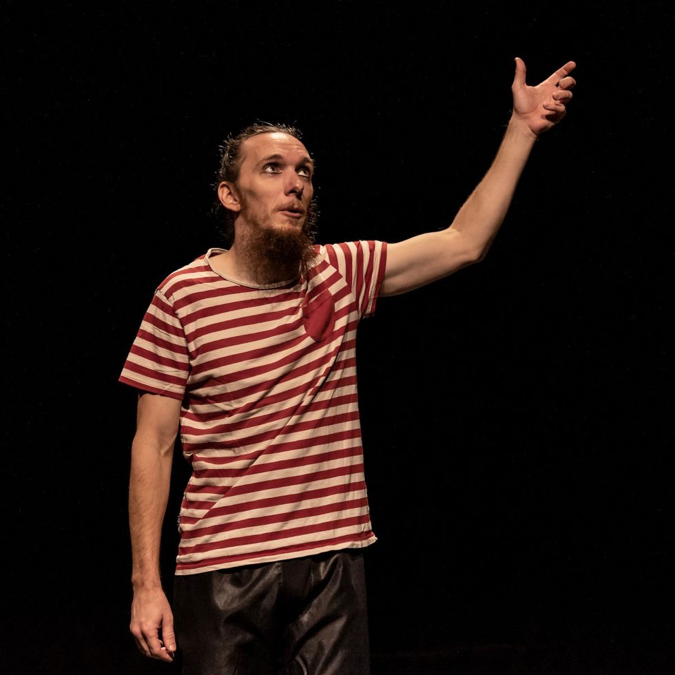 Tomaš on stage in little boy’s clothes, holding his invisible mother’s hand