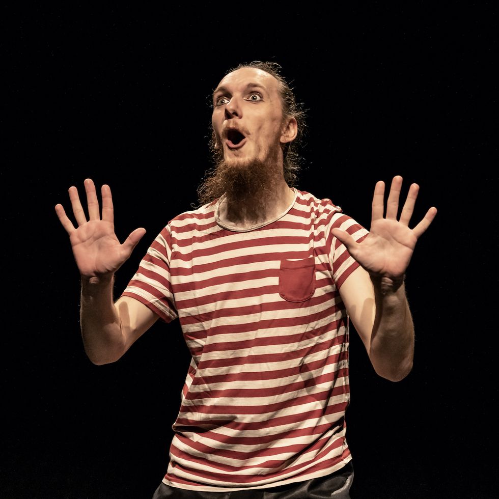 Tomaš on stage in little boy’s clothes, looking very excited through an invisible glass wall