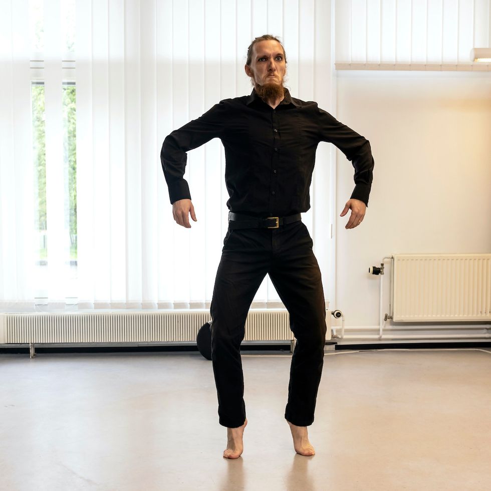 Tomaš on his toes with arms a little apart, appearing larger than usual