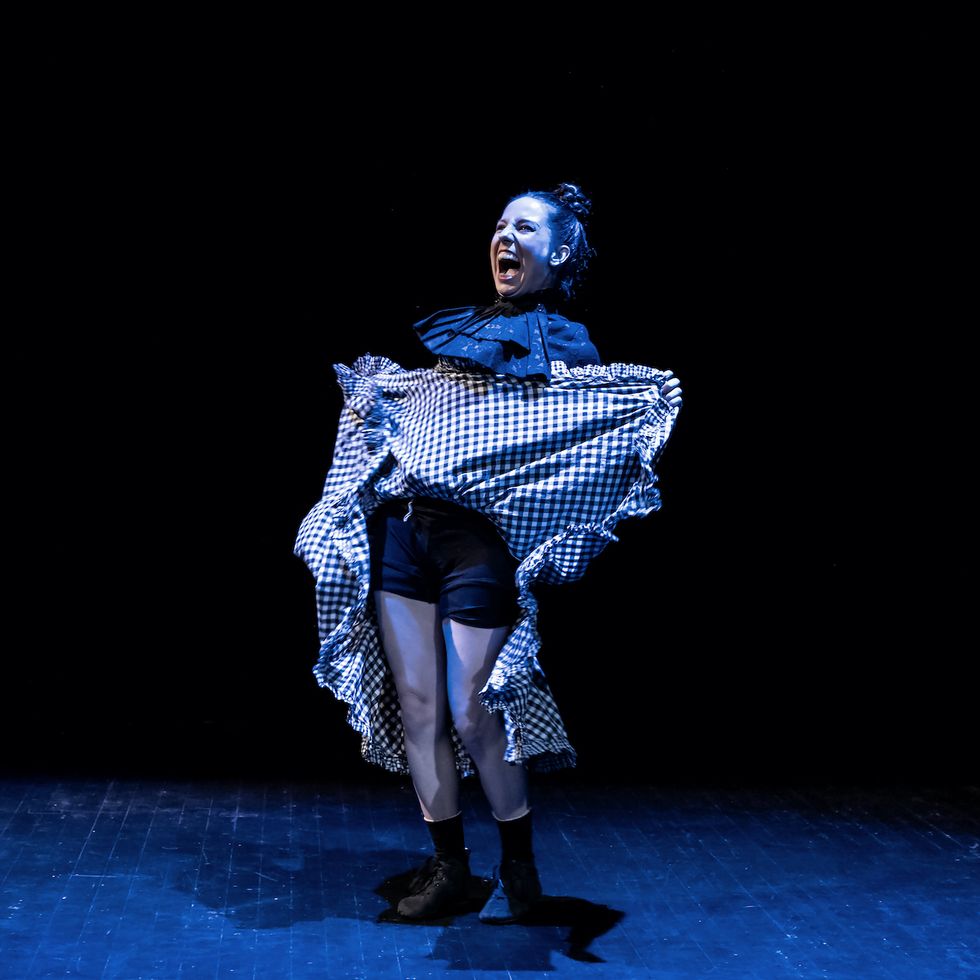 Eliška on stage, laughing and lifting her skirt