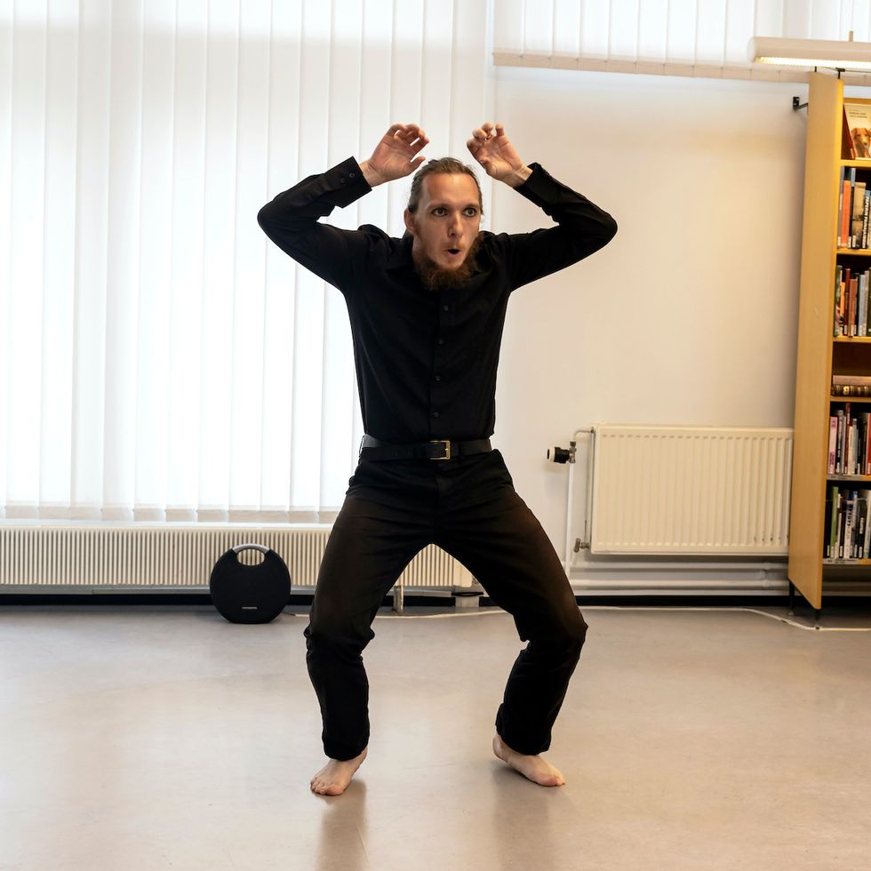 Tomaš crouching a bit, holding his imaginary horns